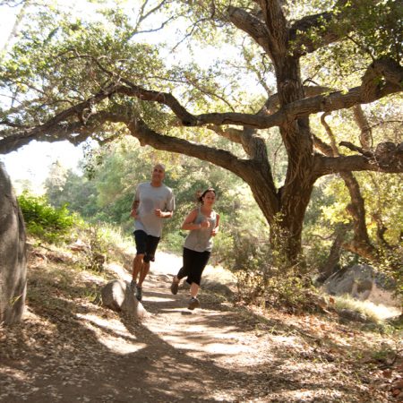 A couple jogs on a nature path at Rancho La Puerta Spa