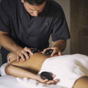 A guest enjoying a hot stone massage at Salamander Spa