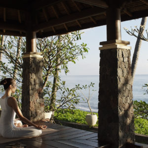 A guest meditates by the sea at the Spa Village Resort in Tembok, Bali, Indonesia